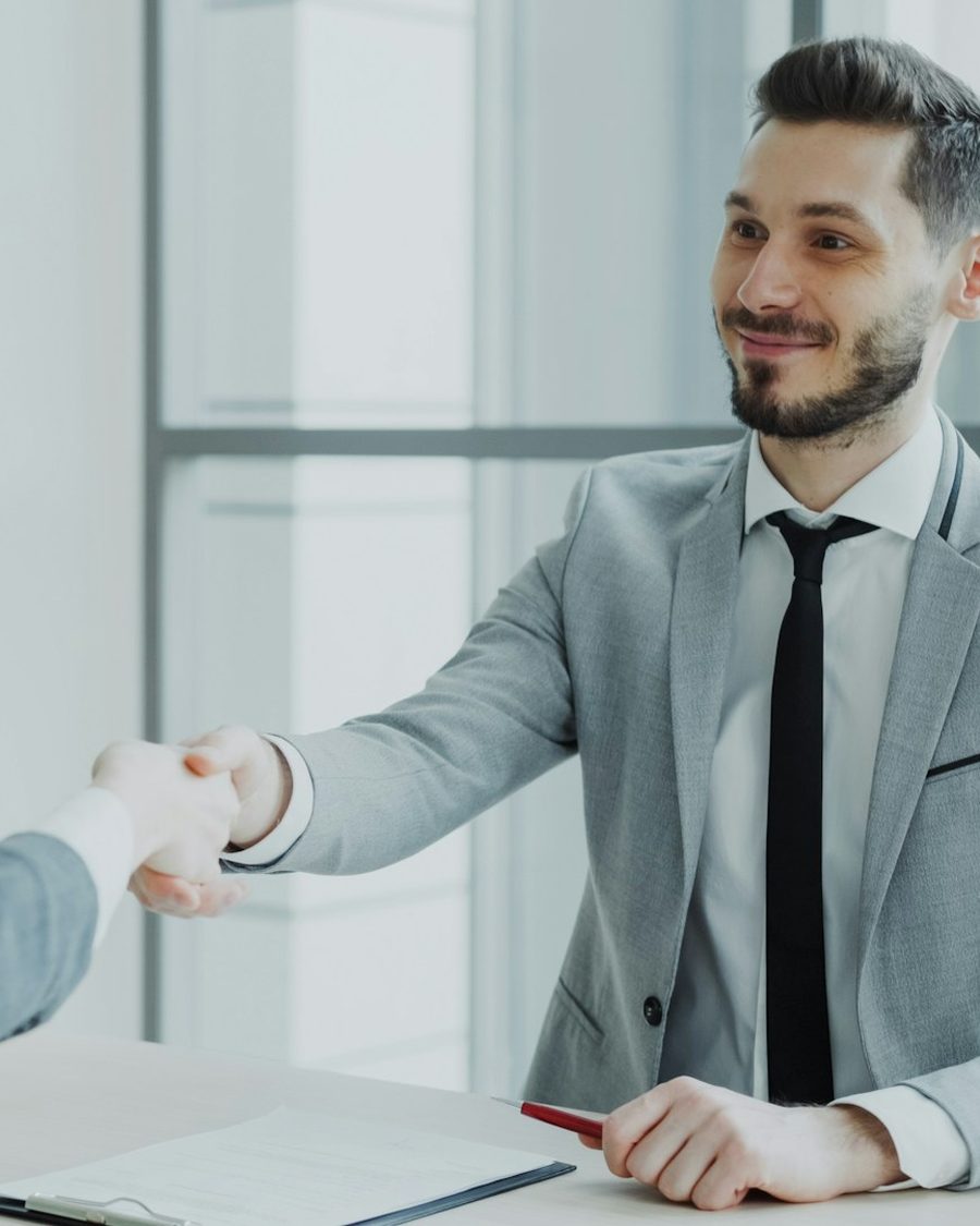 Consultor e cliente apertando as mãos em uma reunião de negócios